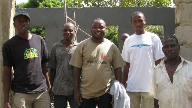 Photo of Team members in front of new community development centre in the village of Tevele.