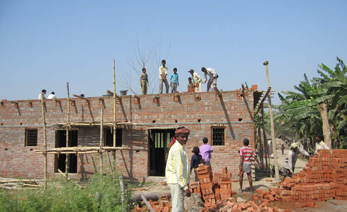 Photo of workers building the roof on the new schoolhouse